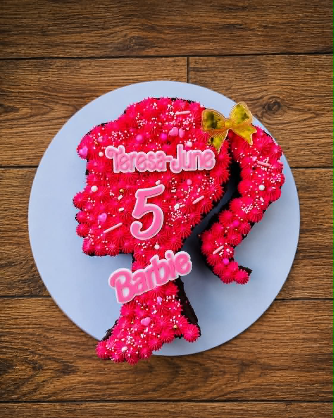 Hot pink Barbie silhouette shaped birthday cake for Teresa-June's 5th with sprinkles and gold bow topper