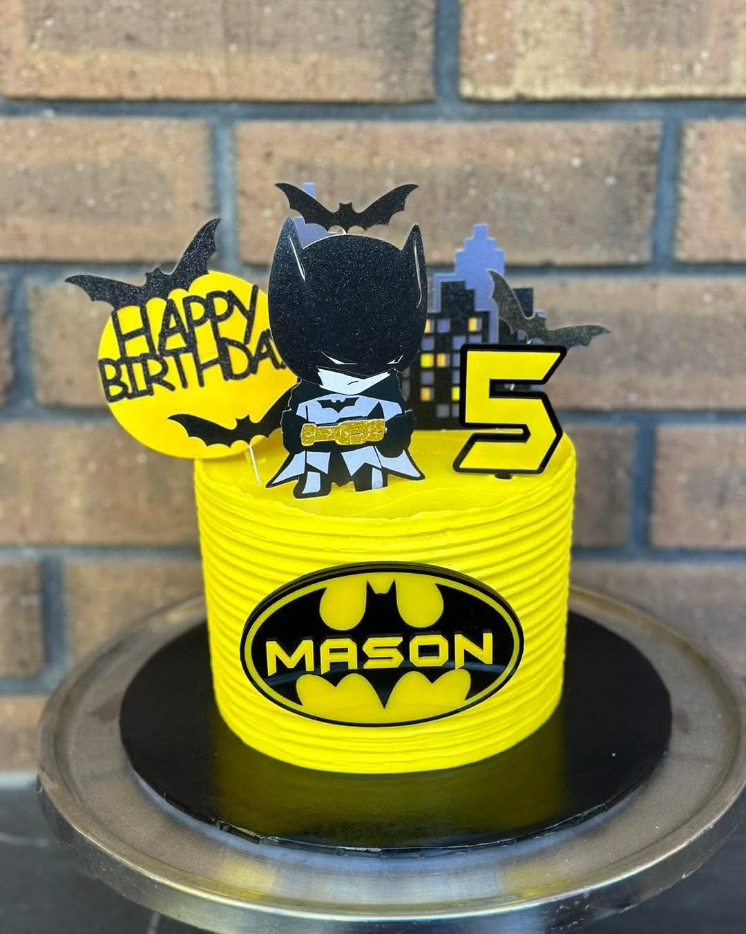 Yellow Batman birthday cake for Mason's 5th with Batman logo, Batman figurine topper, bat toppers and Gotham skyline