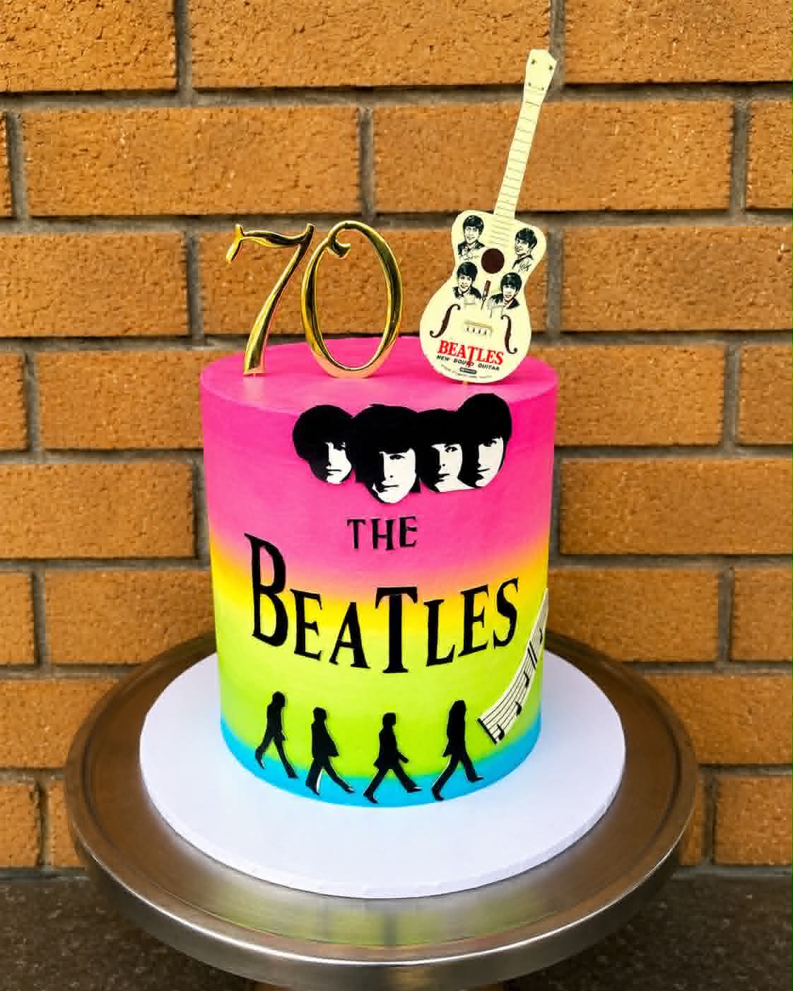 Rainbow ombre Beatles 70th birthday cake with pink to green gradient, Beatles silhouette, Abbey Road walkers, gold 70 topper and Beatles guitar topper