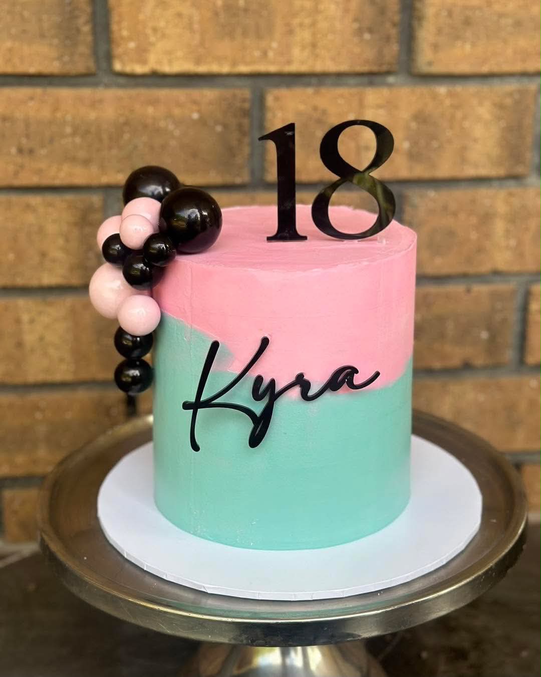 Pink and mint two-tone 18th birthday cake for Kyra with black pearl ball cluster, black acrylic 18 topper and Kyra name plaque