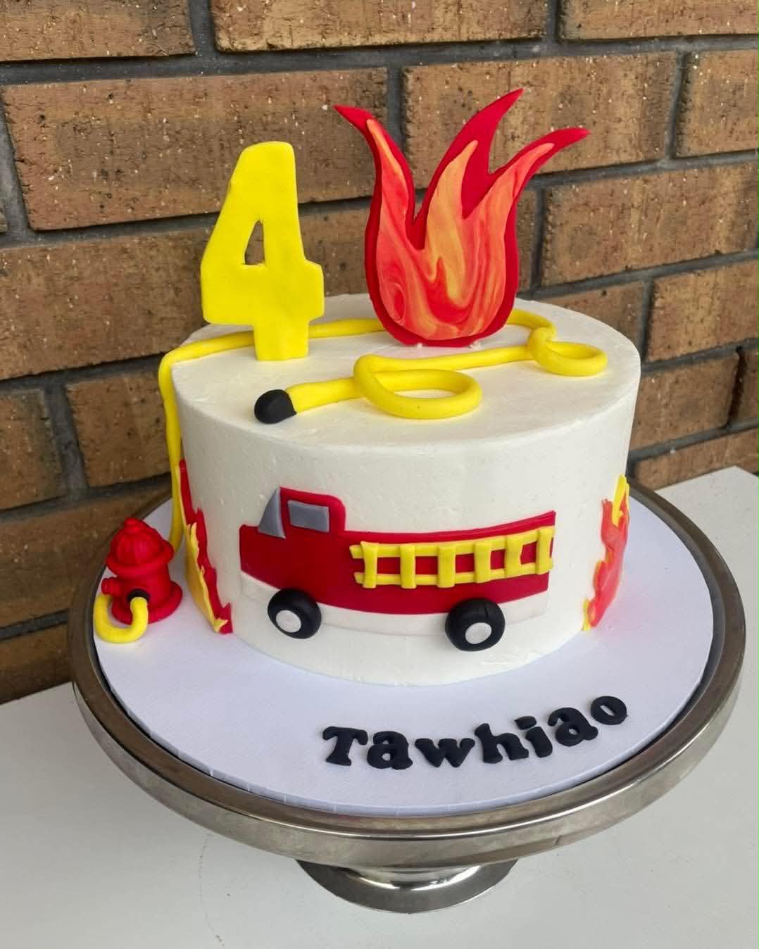 White fondant fire truck birthday cake for Tawhiao's 4th with yellow hose, flame topper and fire hydrant