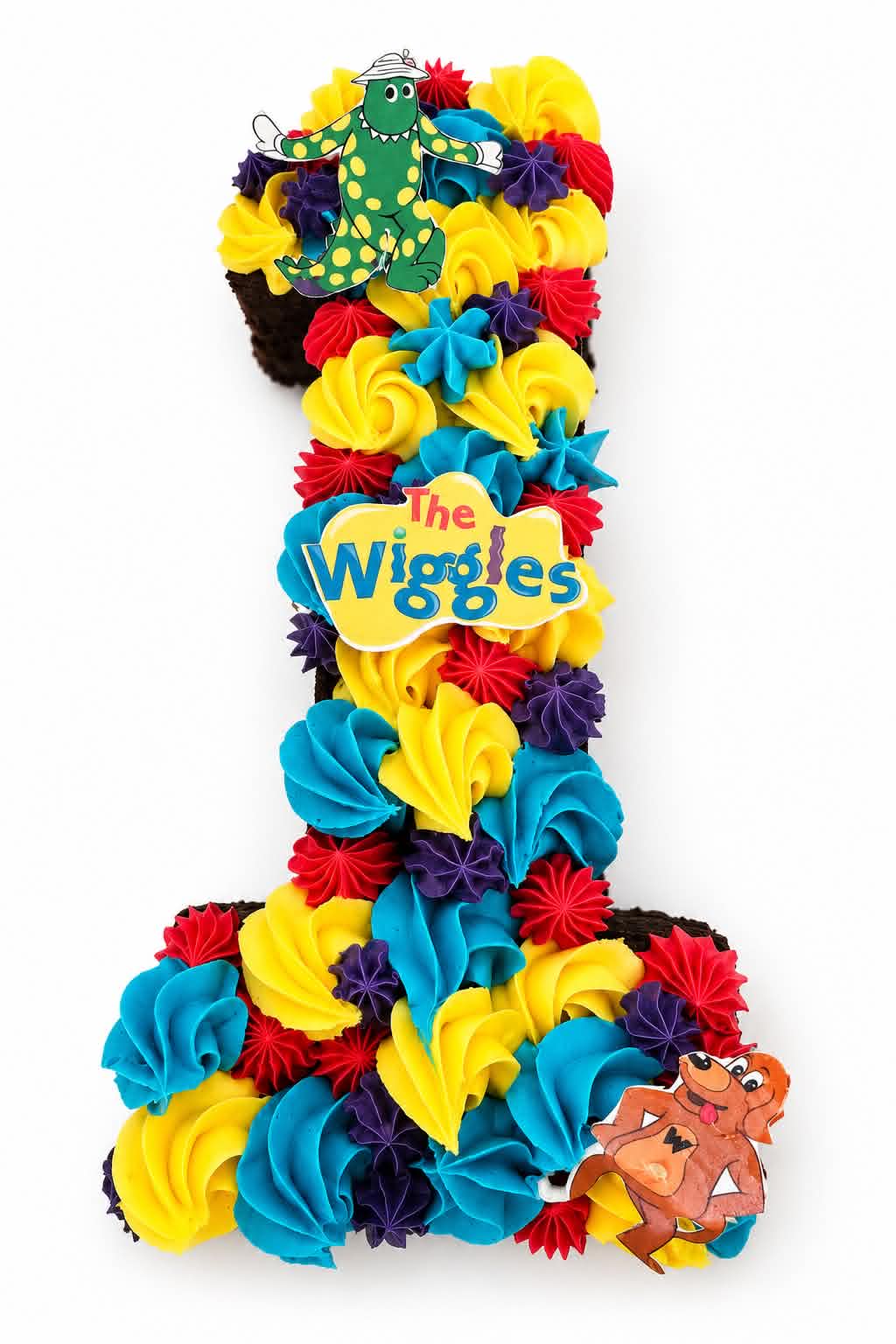 Number 1 shaped Wiggles birthday cake with yellow, blue, red and purple buttercream rosettes and Dorothy the Dinosaur topper
