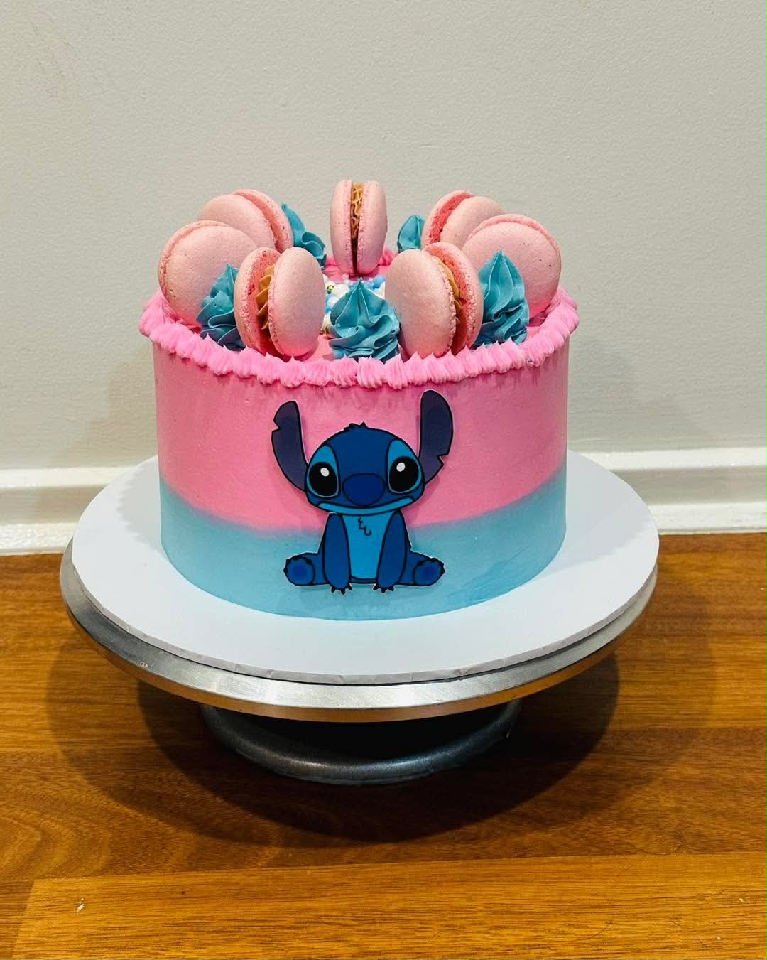 Pink and blue ombre Stitch birthday cake with pink macarons, blue buttercream rosettes and Stitch edible print
